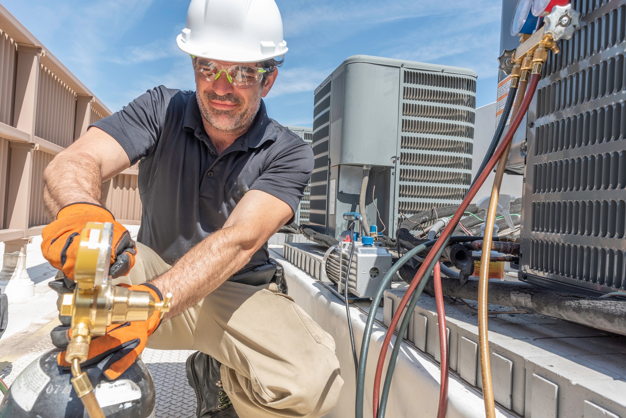 Hvac tech working on installing a new air conditioner unit on a roof top