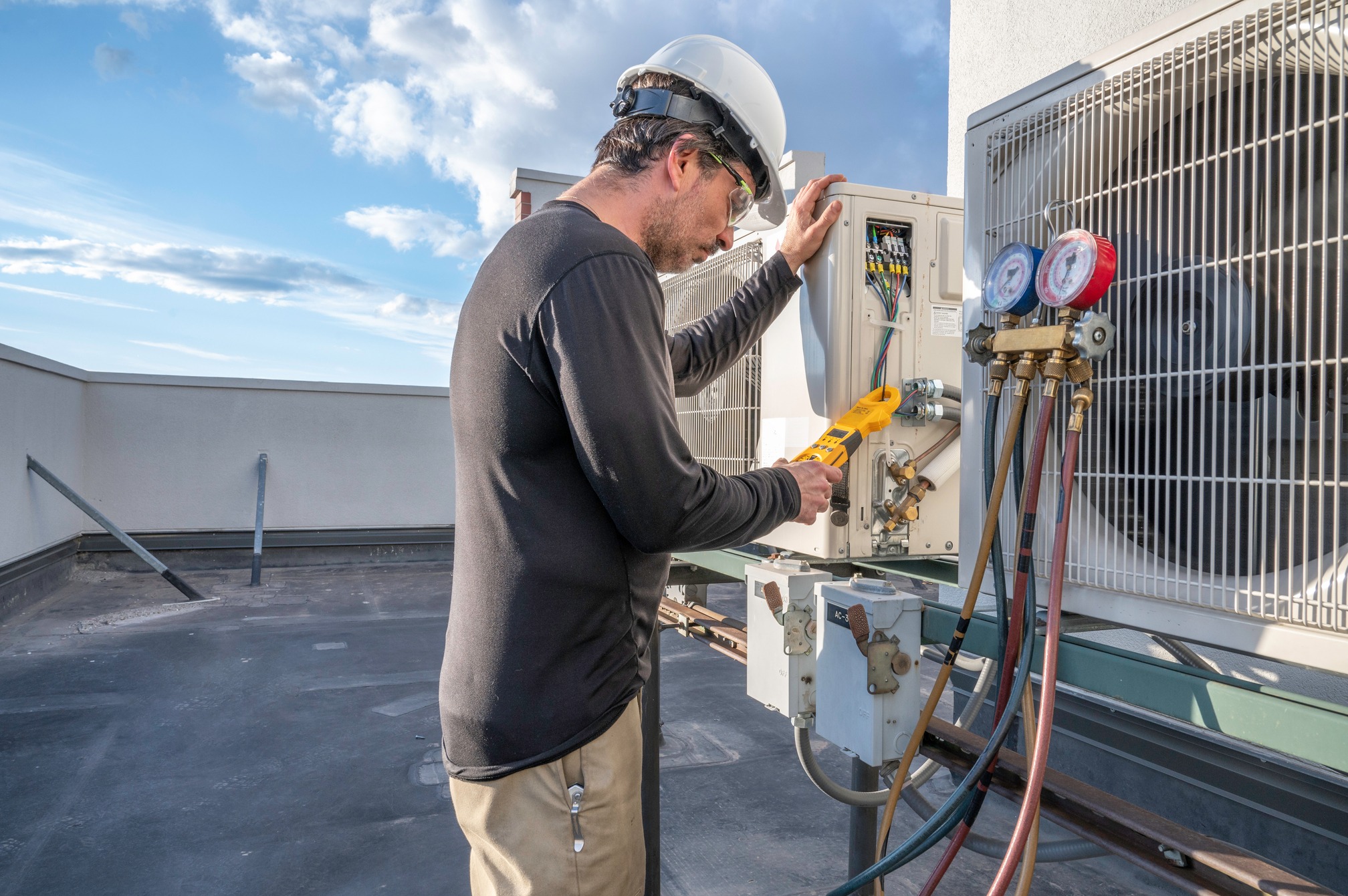 Professional HVAC technician taking an amperage reading on a mini-split ductless air conditioning system.